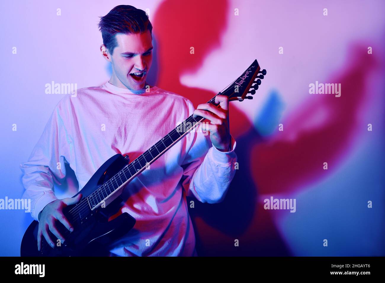 Portrait of young man artist singing, screaming, playing electric