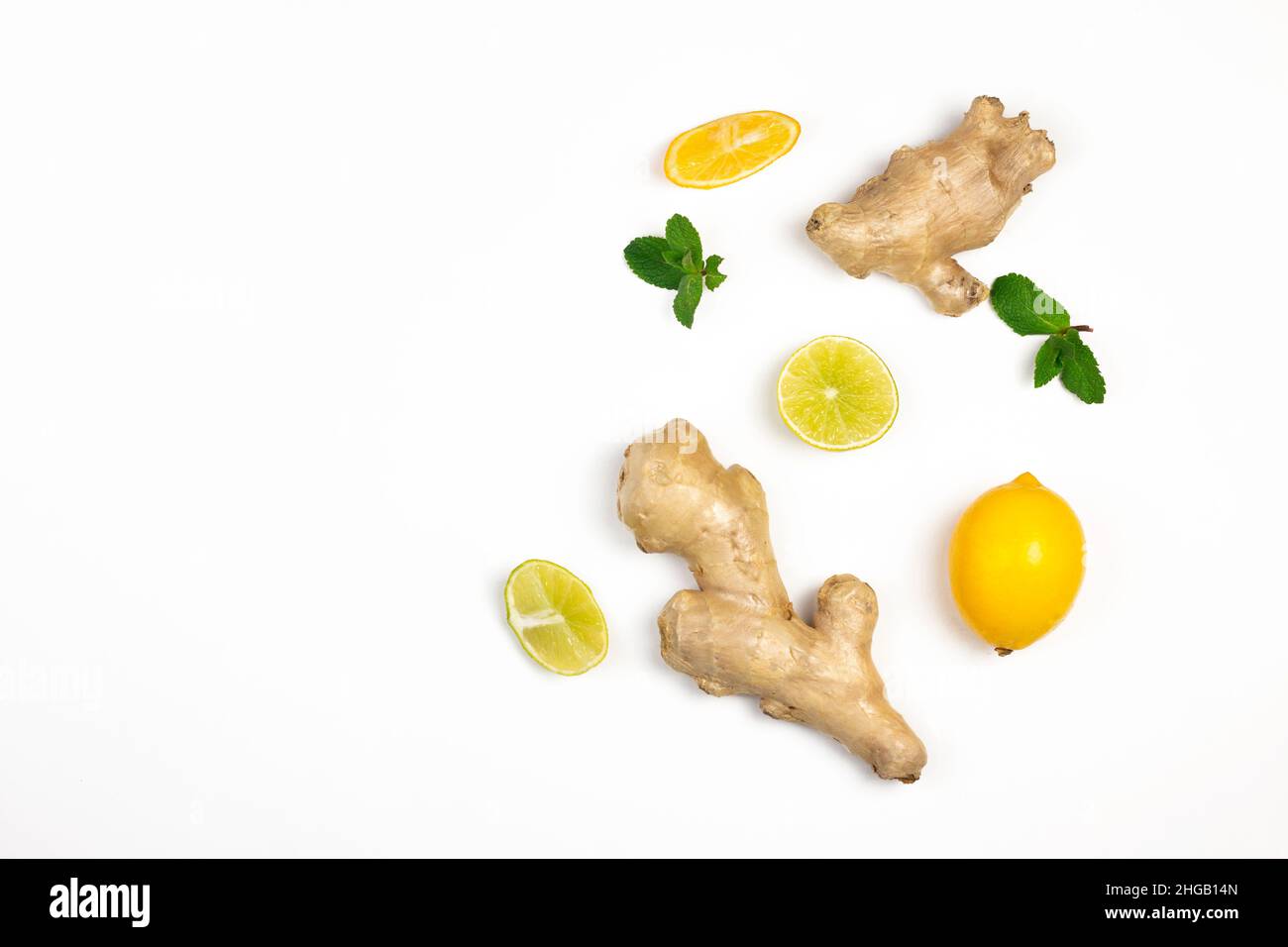 Ginger root, lemons slices and green fresh mint flat lay isolated on white background. Food balance and detox concept composition. Stock Photo