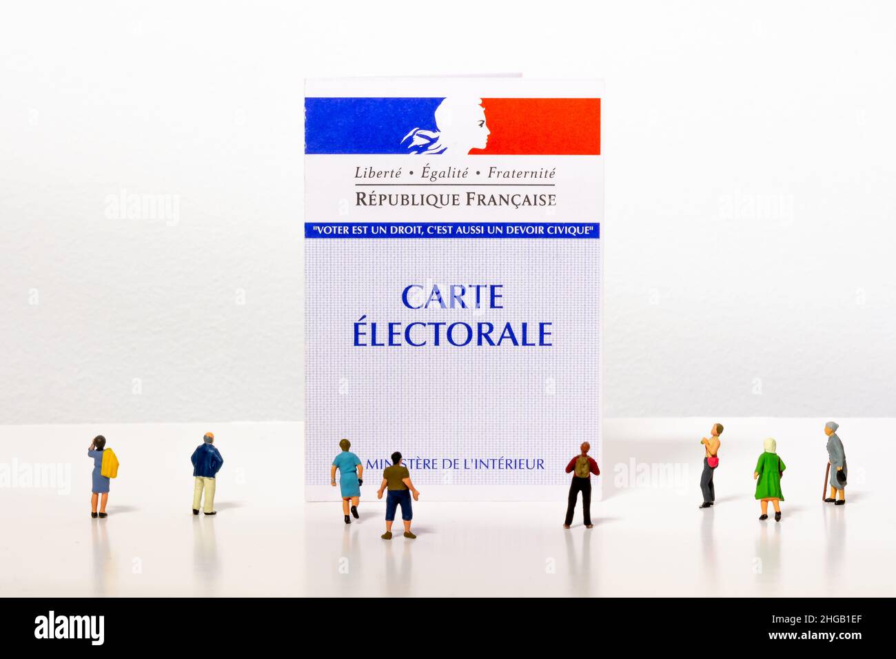 Tiny citizen figurines looking at a French electoral card. Each voter receives an elector card allowing them to vote in elections in France Stock Photo