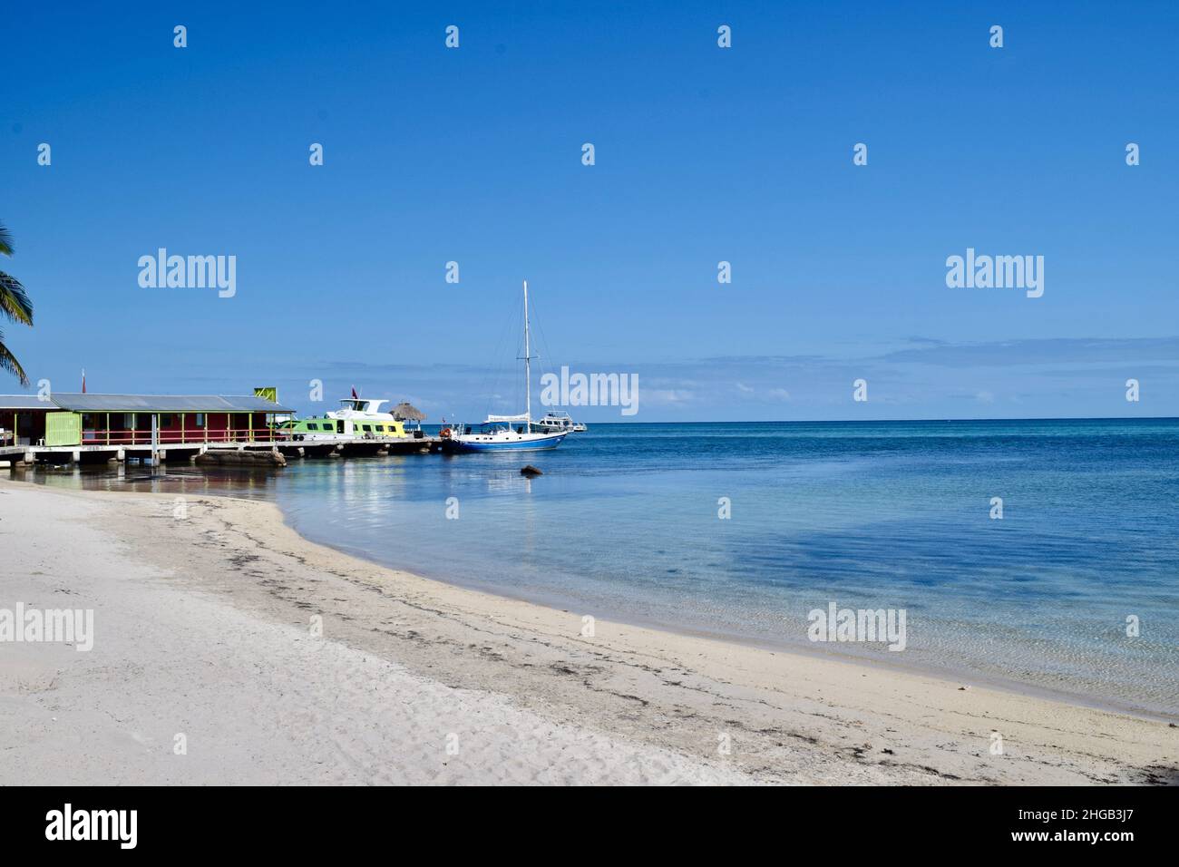 The calm, clear water of the Caribbean Sea along the beach in San Pedro, Belize with boats