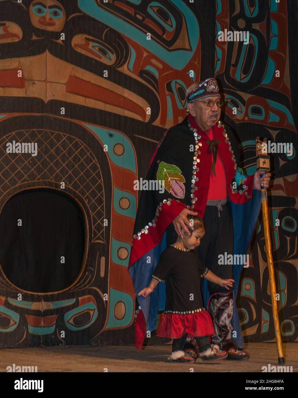 A Saxman tribal elder discusses the Saxman culture and history with his grandchild by his side. Stock Photo