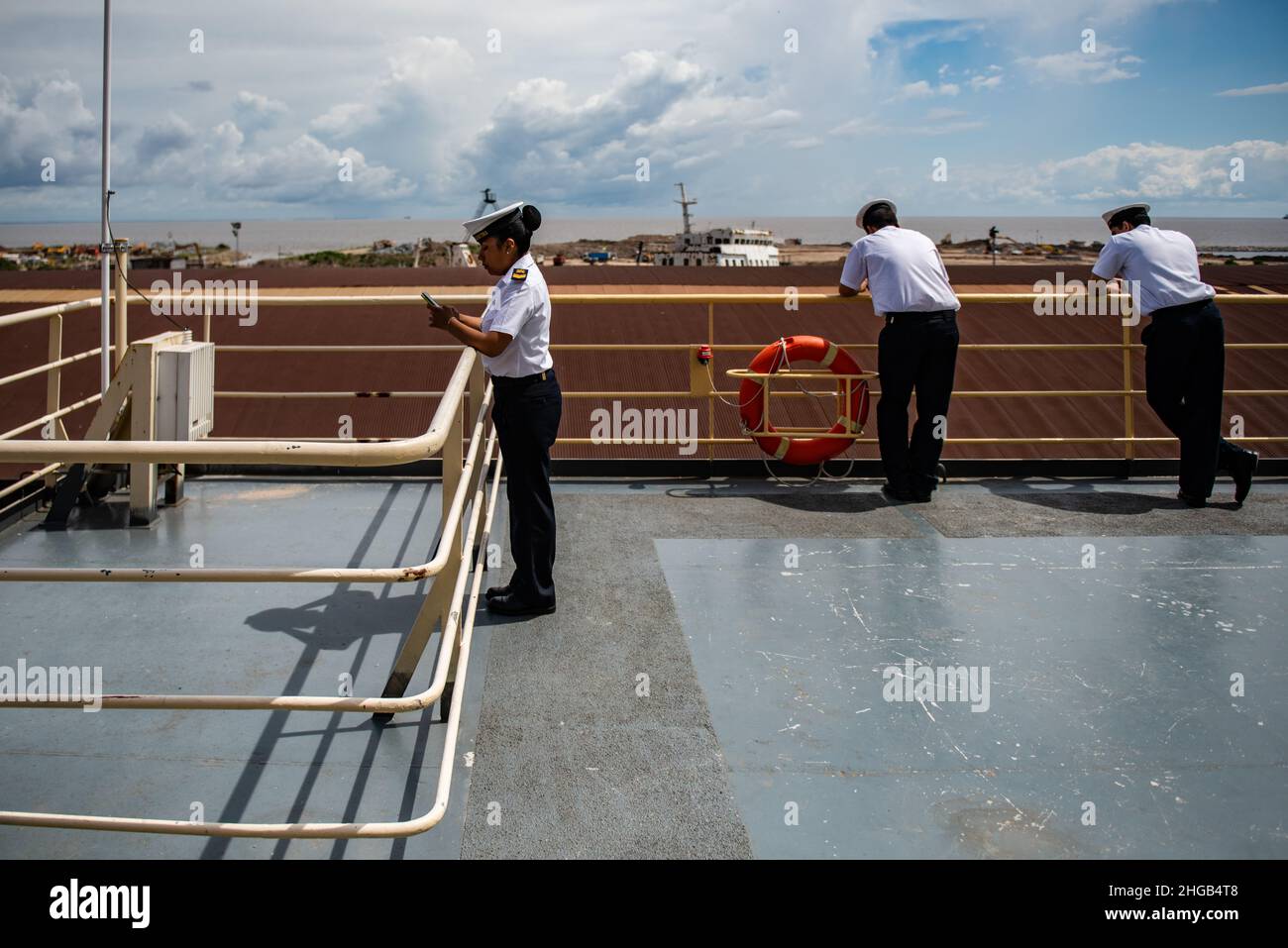 Three sailors leaning on a railing are seen minutes before the icebreaker Almirante Irizar sets sail. Stock Photo