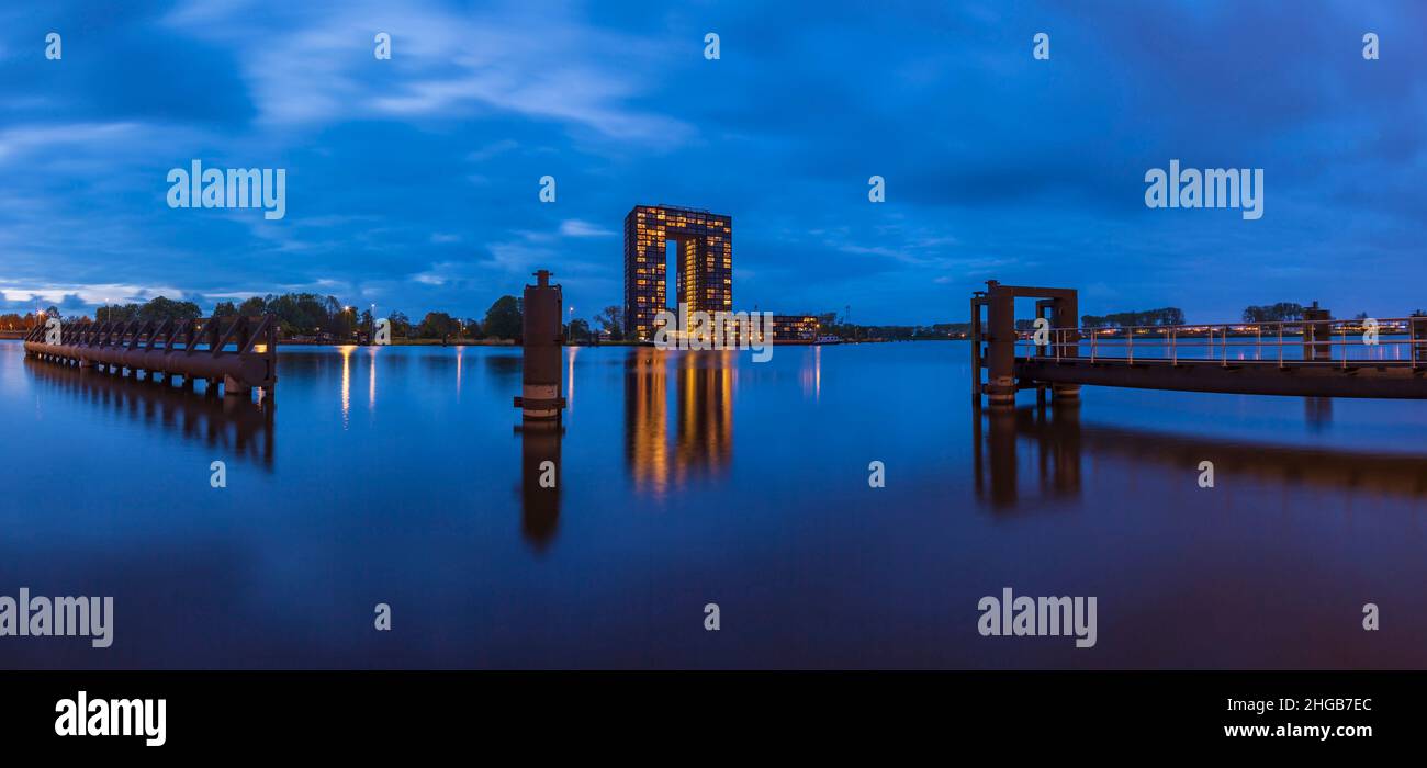 Evening landscape with illuminated building in Groningen city in the Netherlands. Blue sky in blue hour. Stock Photo
