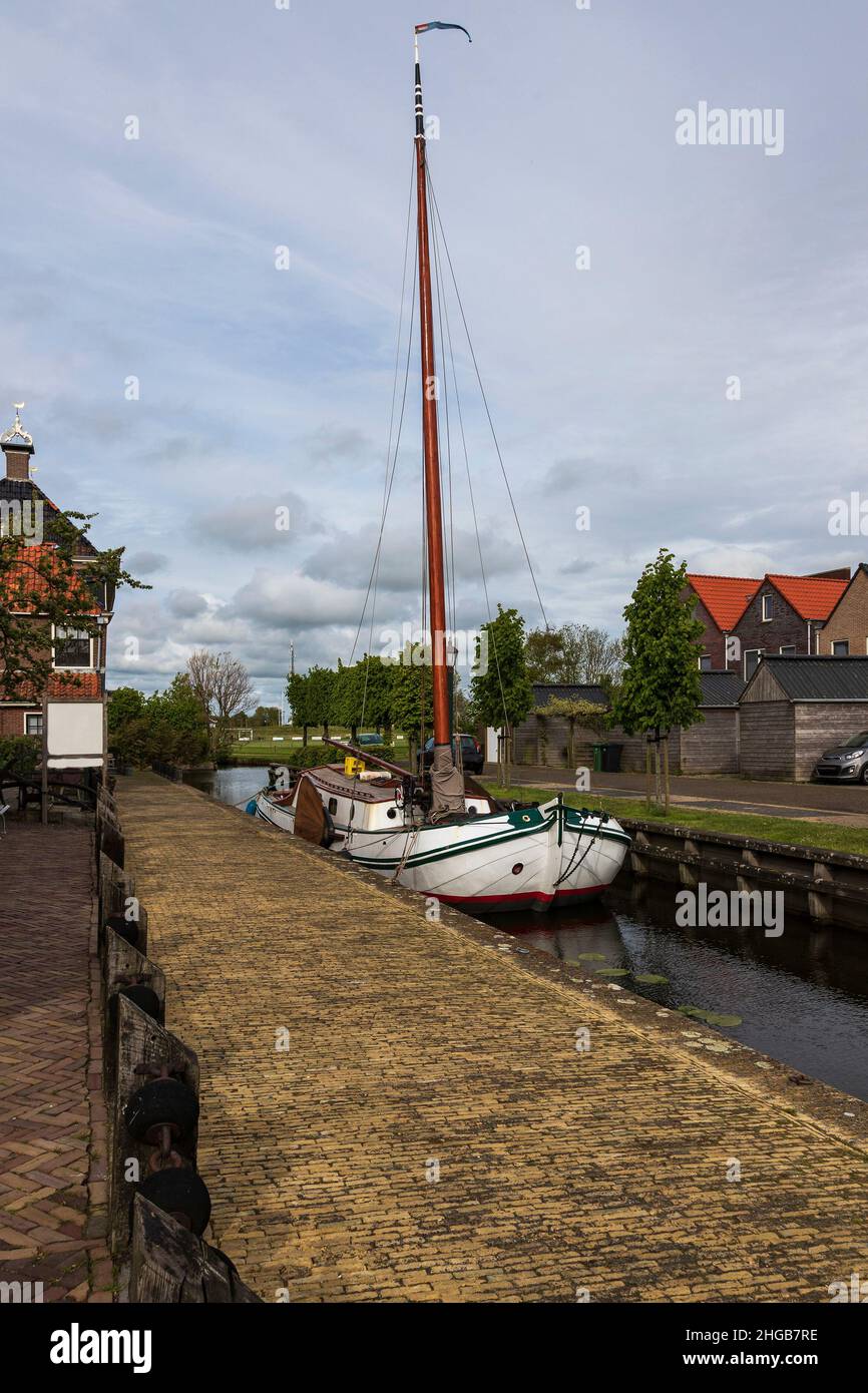 Water canal for boats between houses in Hindeloopen in Holland. Stock Photo