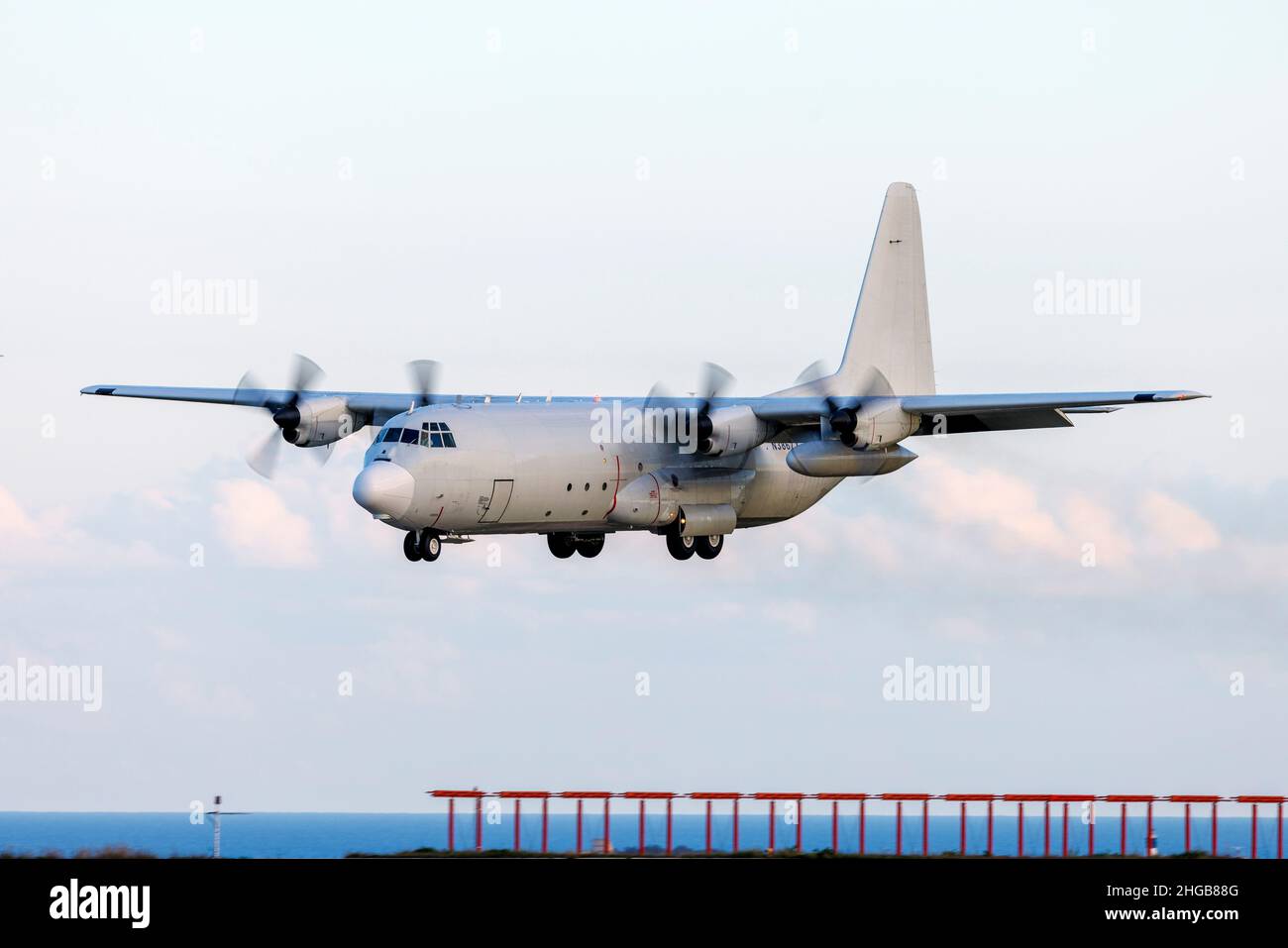 Tepper Aviation Lockheed L-100-30 Hercules (L-382G) (REG: N3867X) coming in very low runway 31 in the late evening. Stock Photo