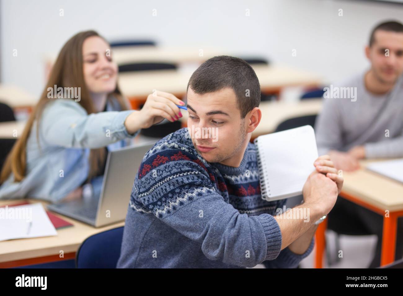 Students teasing each other having fun during class in a modern classroom Stock Photo