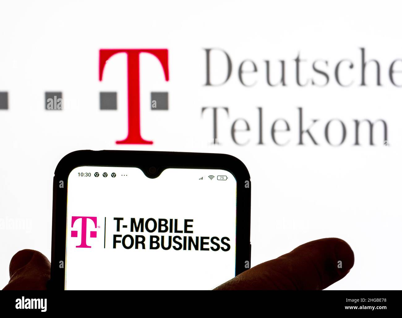 In this photo illustration, seen on - the logo T-Mobile background in screen Photo Deutsche AG is the for the Telekom Business smartphone Alamy with displayed logo a Stock
