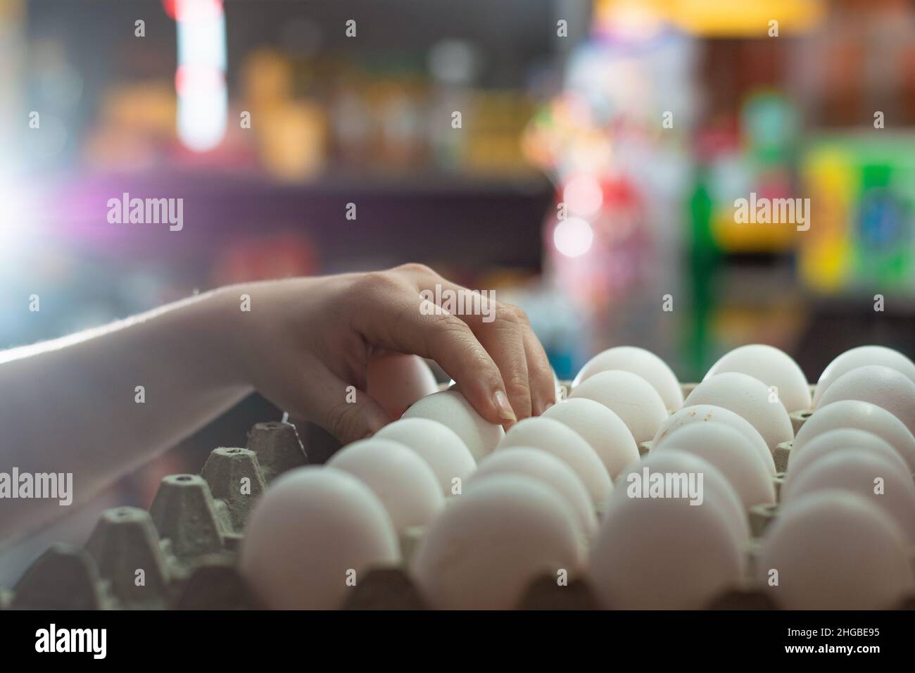 hand of a woman taking some white chicken eggs, girl selling eggs in a