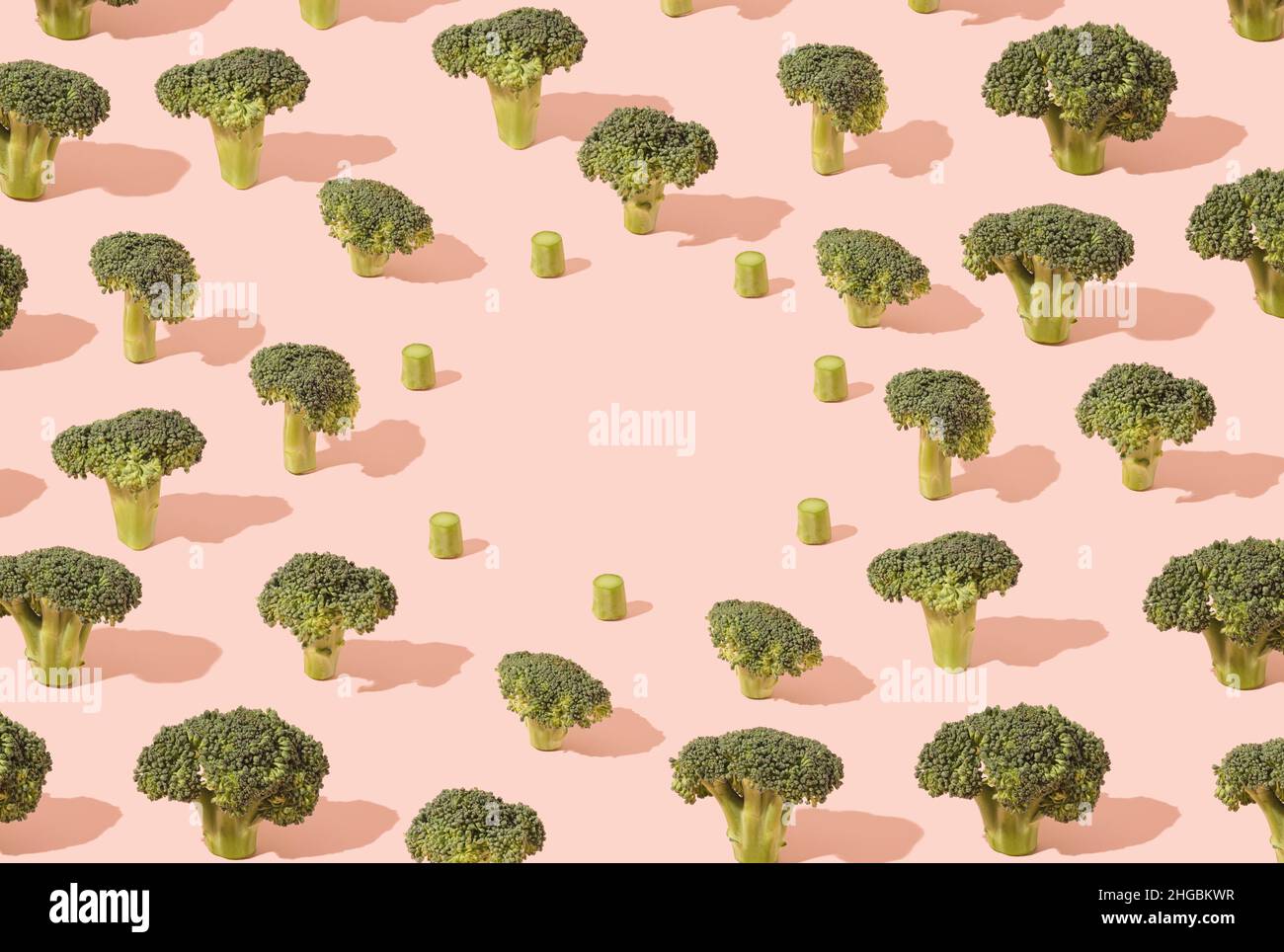 Various broccoli flowers pattern on a pastel pink background. Climate change minimal concept. Stock Photo
