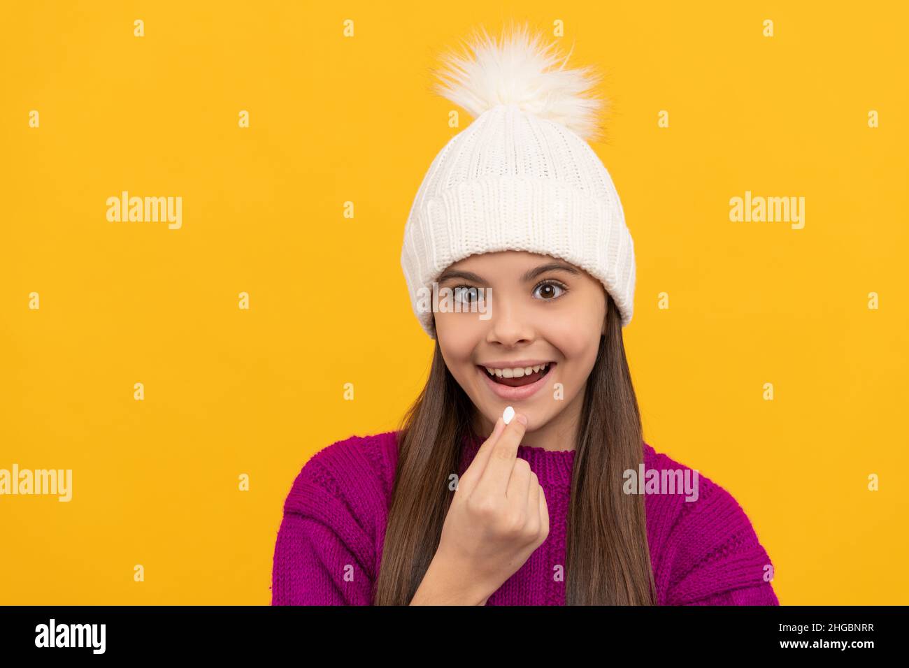 childhood health. child in winter hat taking pill. food supplement. Stock Photo