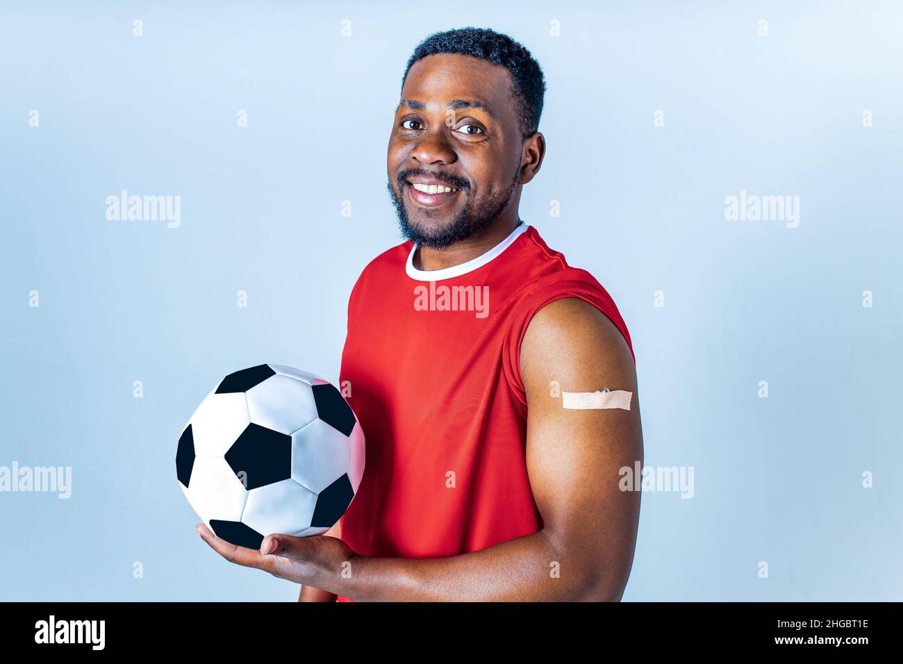afro american sportsman showing his arm after receiving a vaccine in studio Stock Photo