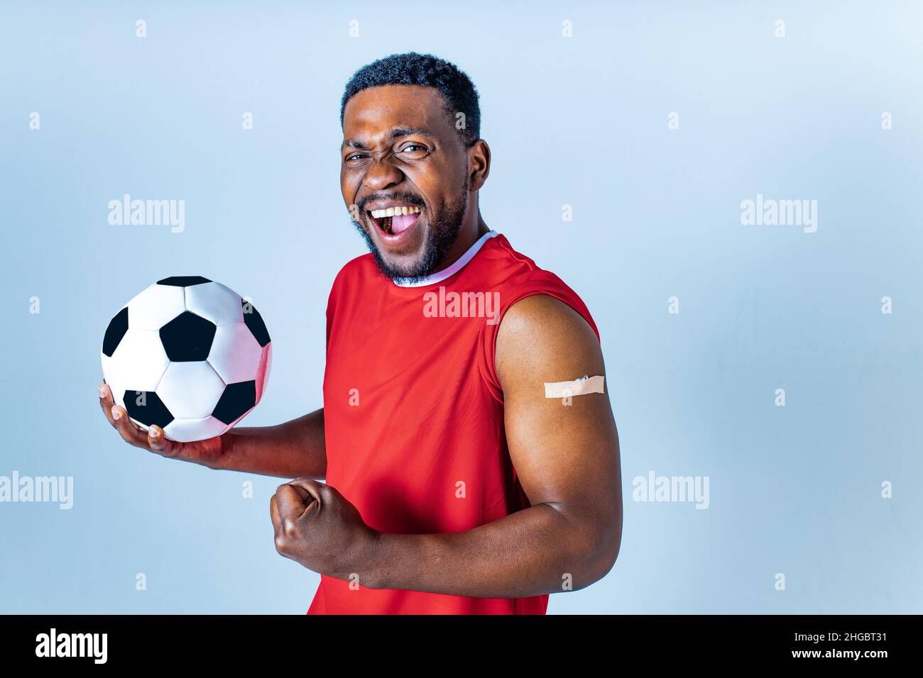 afro american sportsman showing his arm after receiving a vaccine in studio Stock Photo