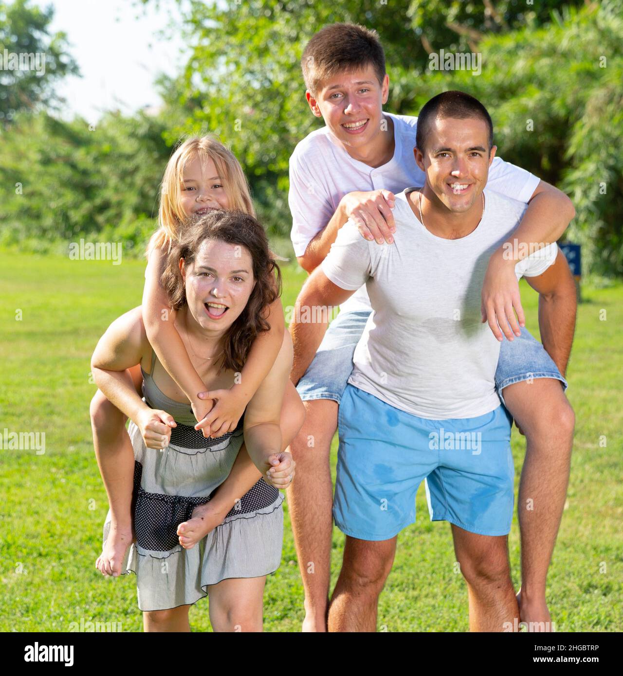 Parents piggybacking children Stock Photo