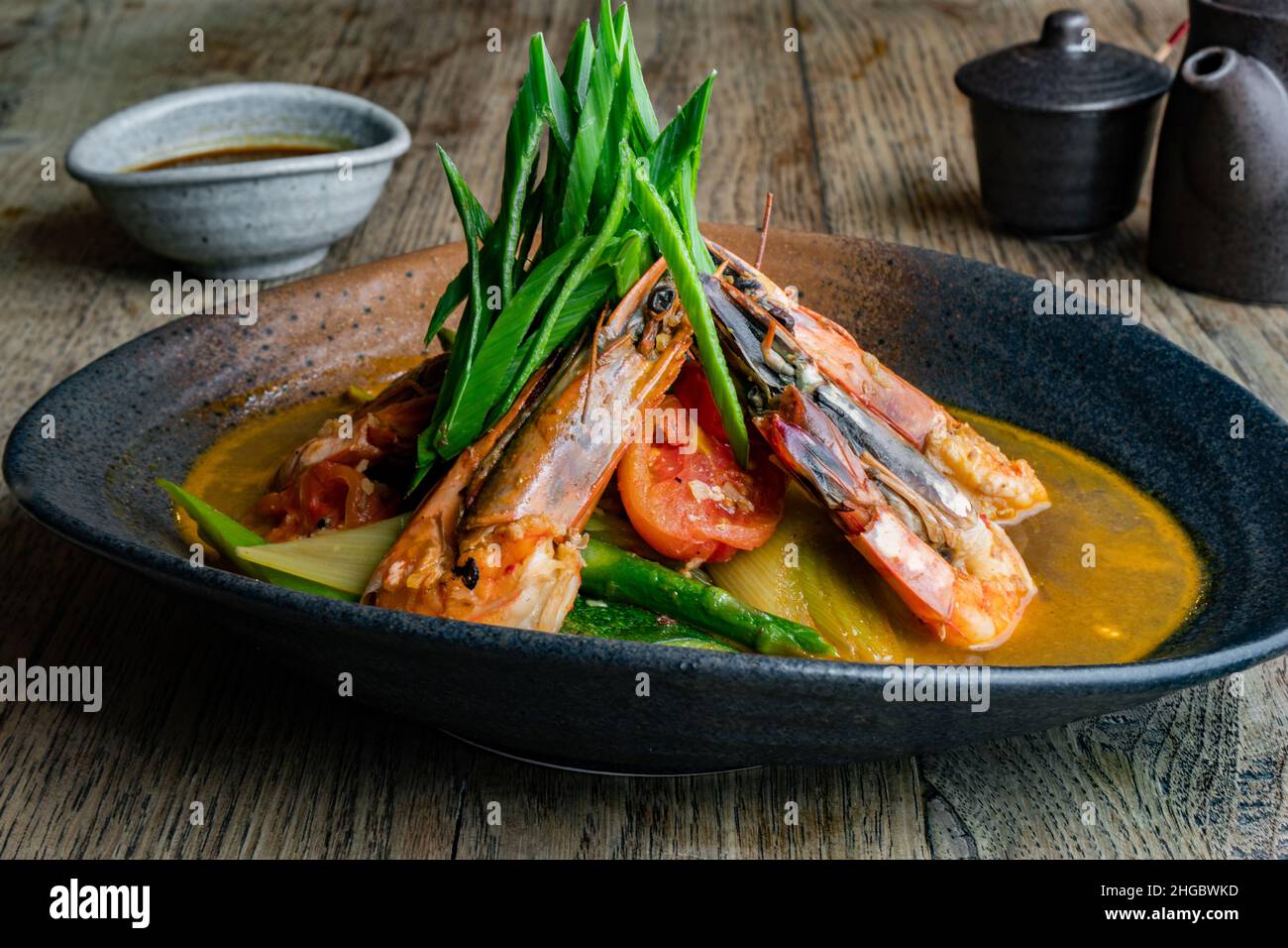 Japanese dish with shrimps, prawns, lobster and other seafood, topped with leeks. Stock Photo