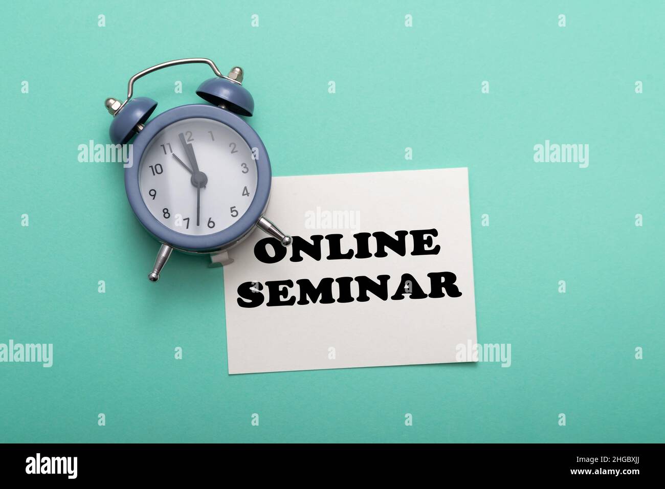 business card with text online seminar on a green background. There is a clock next to it