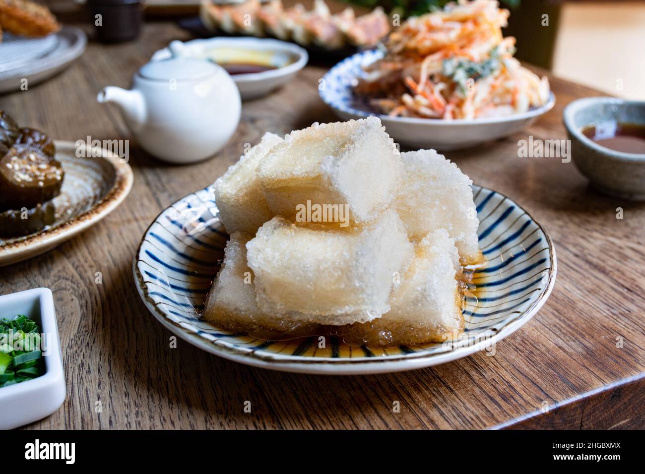 Agedashi tofu, a Japanese traditional dish, with various Japanese dishes in the background. Stock Photo