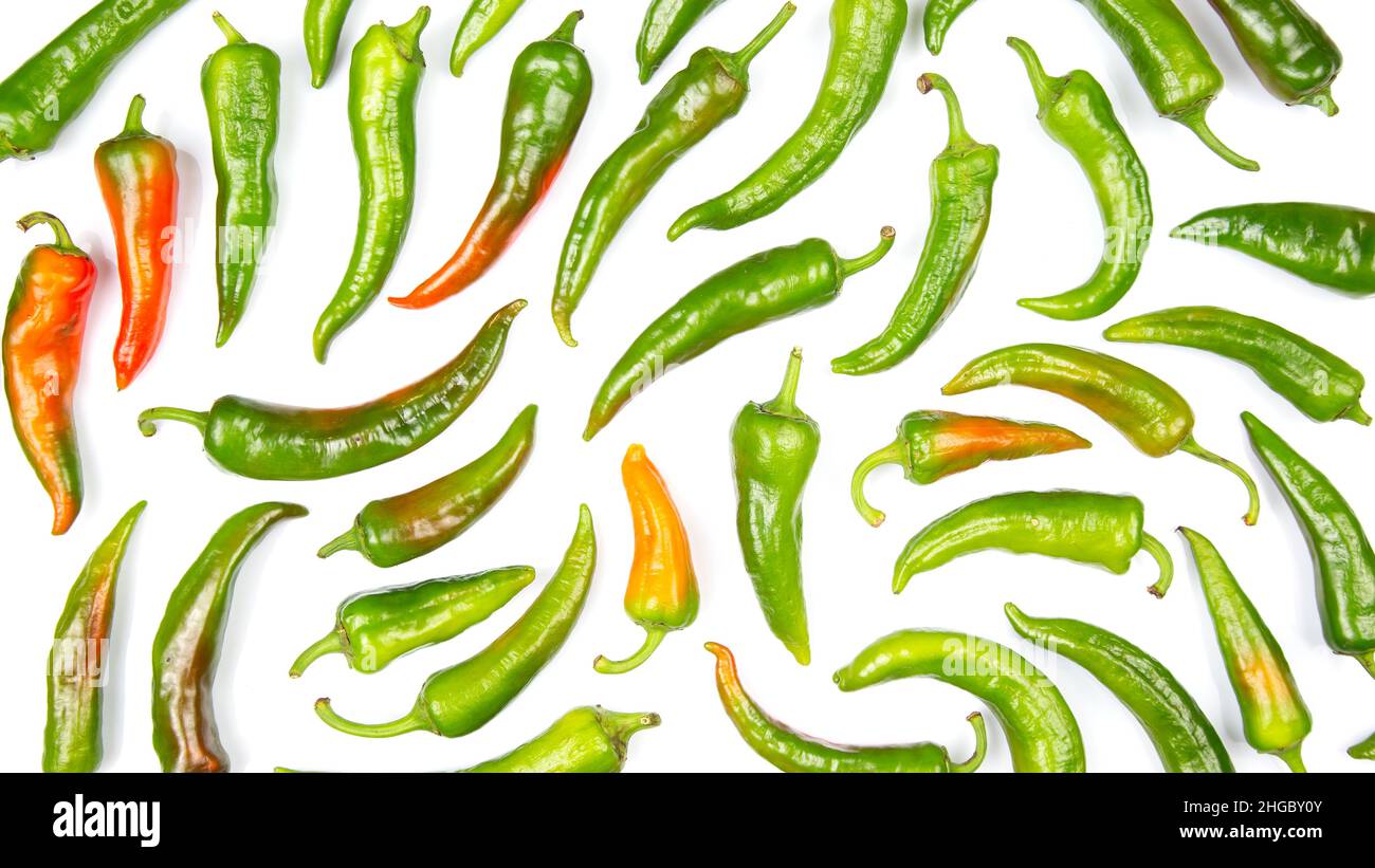 green hot peppers evenly spread on a white background. vitamin