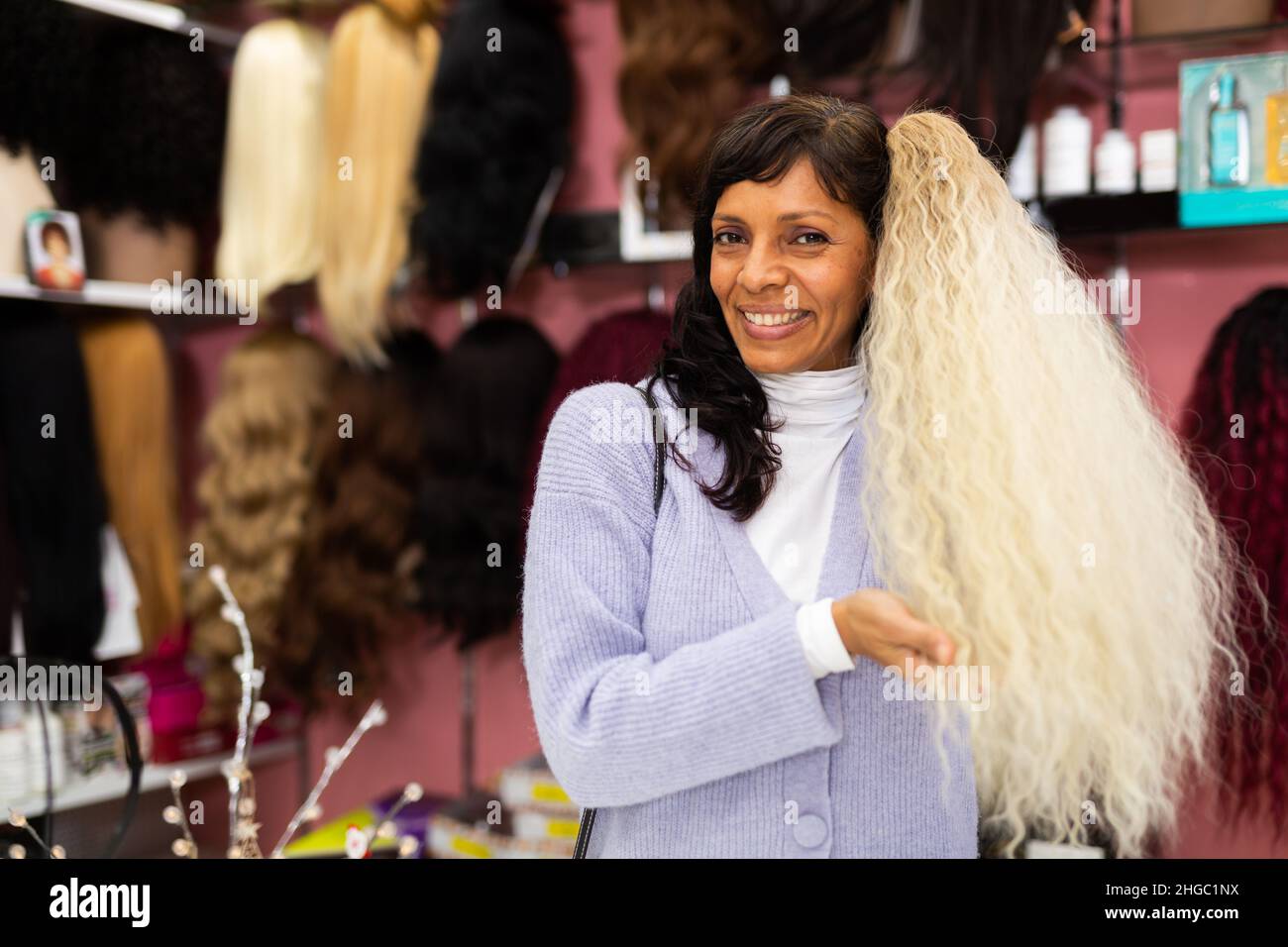 Woman choosing natural wig at specialty boutique Stock Photo