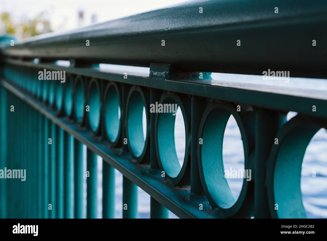 Perspective of green, urban, iron railing in a city. Selective focus ...