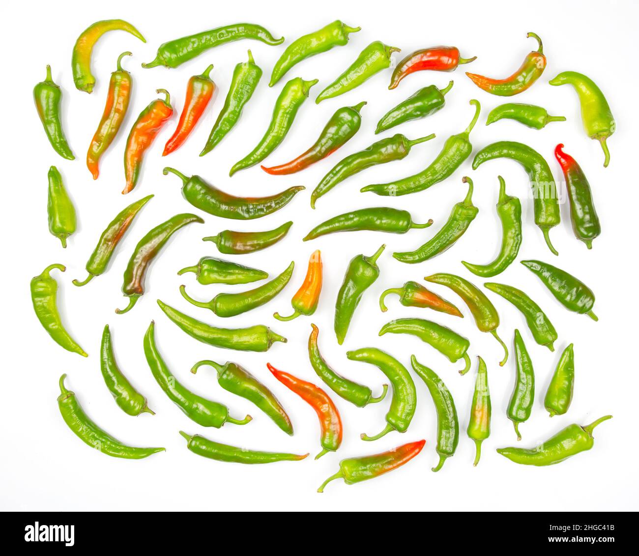 green hot peppers evenly spread on a white background. vitamin