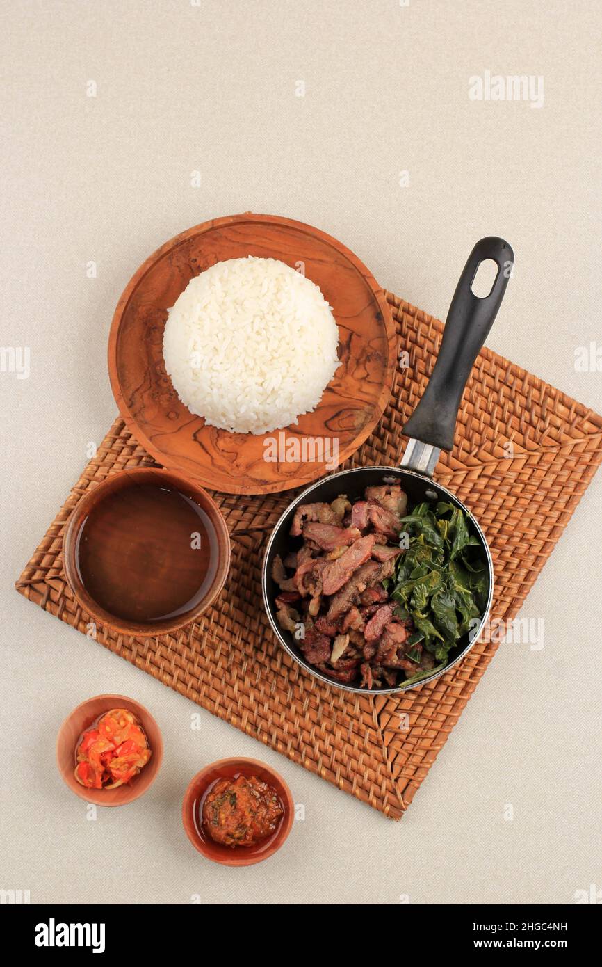 Sei Sapi or Beef Sei is Indonesia Traditional Smoked Beef, Served with Boiled Cassava Leaves and Sambal Luat or Sambal Matah. Typically Food from Nusa Stock Photo