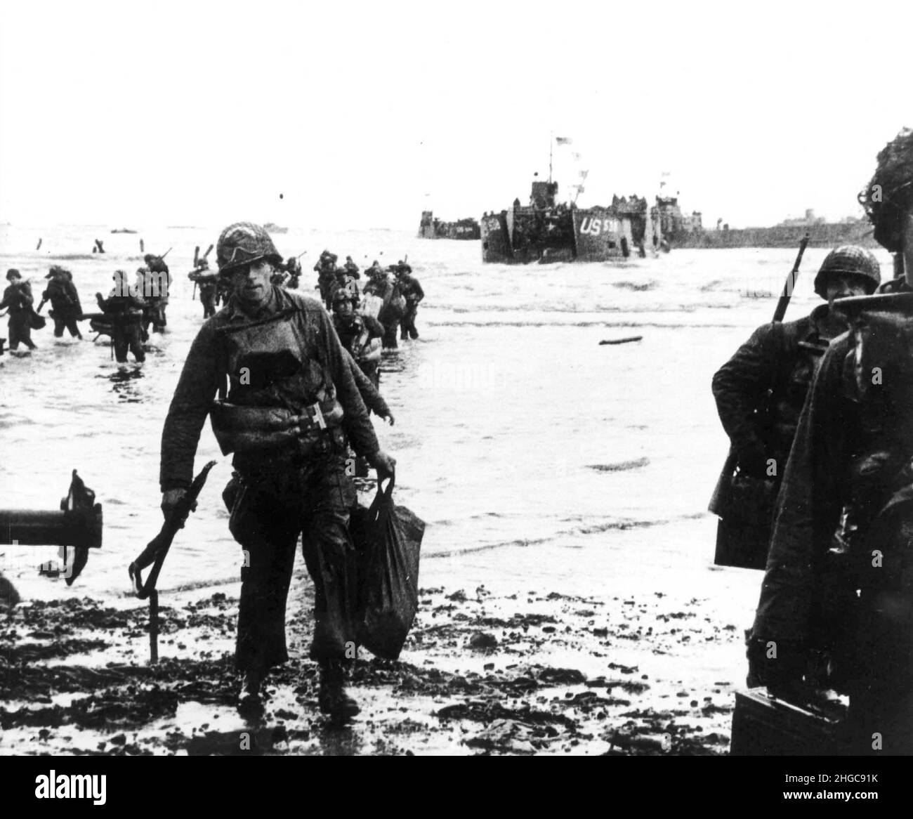 American troops move onto Utah Beach  during the D-Day landings. Landing craft can be seen in the background. Stock Photo