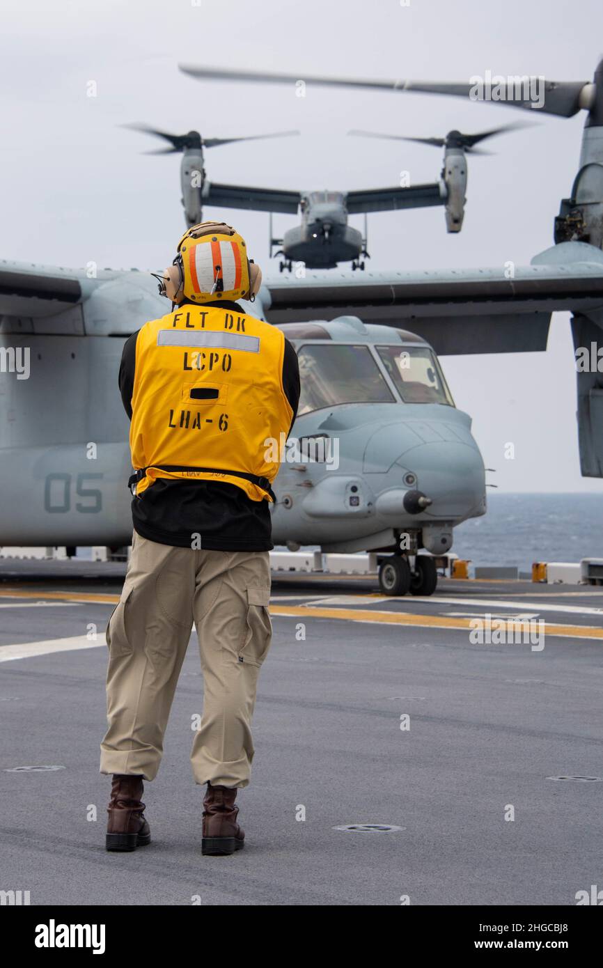 PHILIPPINE SEA (Jan. 18, 2022) Chief Aviation Boatswain’s Mate (Handling) Eduardo Aceves, from Los Angeles, assigned to the forward-deployed amphibious assault ship USS America (LHA 6), observes MV-22B Osprey aircraft from the 31st Marine Expeditionary Unit (MEU) during flight operations. America, lead ship of the America Amphibious Ready Group, along with the 31st MEU, is operating in the U.S. 7th Fleet area of responsibility to enhance interoperability with allies and partners and serve as a ready response force to defend peace and stability in the Indo-Pacific region. (U.S. Navy photo by Ma Stock Photo