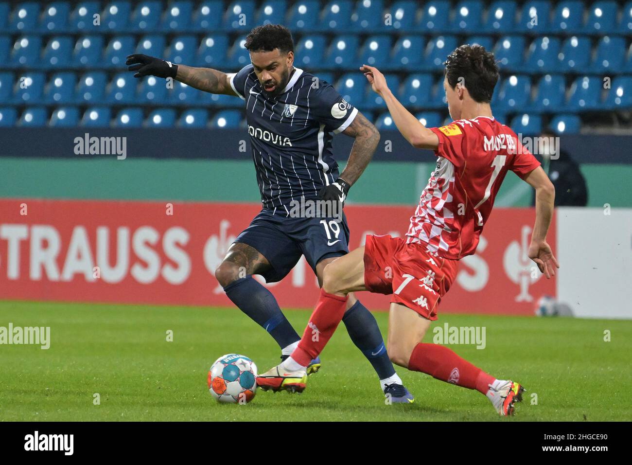 Bochum, Germany. 18th Jan, 2022. Soccer: DFB Cup, VfL Bochum - FSV Mainz 05, Round of 16, Vonovia Ruhrstadion: Bochum's Jürgen Locadia (l) and Mainz's Jae-sung Lee fight for the ball. Credit: David Inderlied/dpa - IMPORTANT NOTE: In accordance with the requirements of the DFL Deutsche Fußball Liga and the DFB Deutscher Fußball-Bund, it is prohibited to use or have used photographs taken in the stadium and/or of the match in the form of sequence pictures and/or video-like photo series./dpa/Alamy Live News Stock Photo