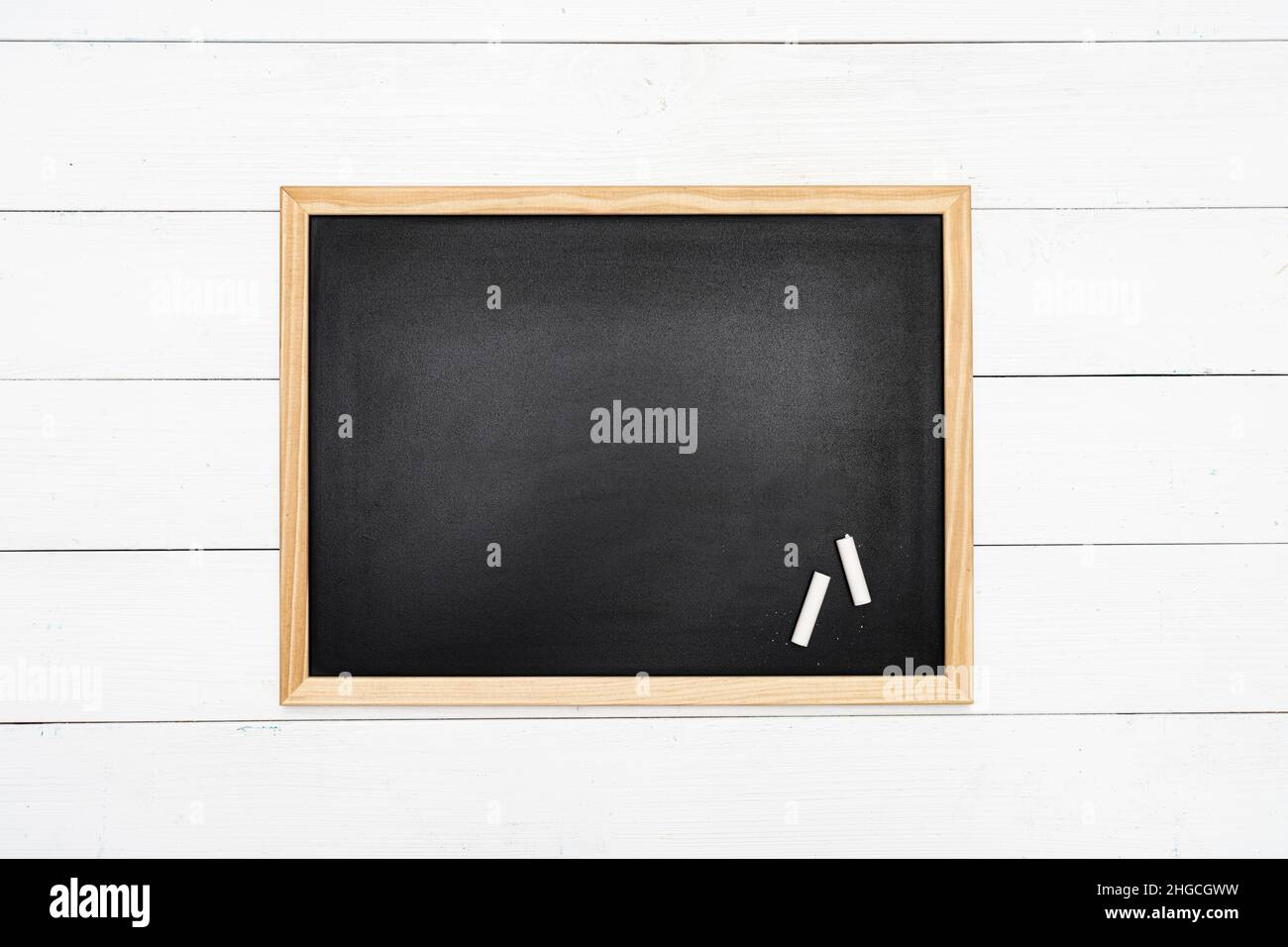 a blank blackboard with white chalk on a white wooden surface Stock Photo