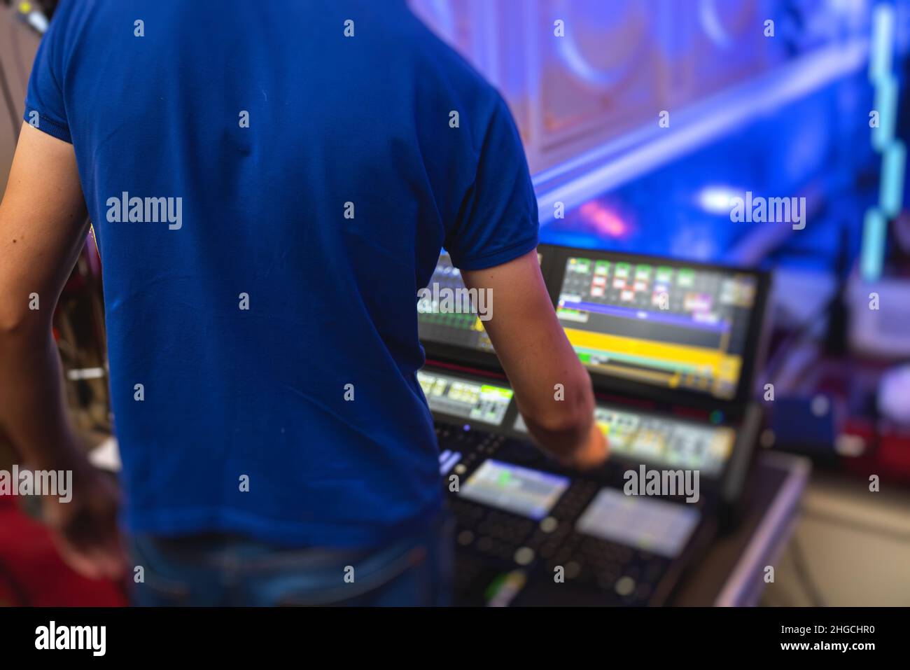 View of lighting technician operator working on mixing console