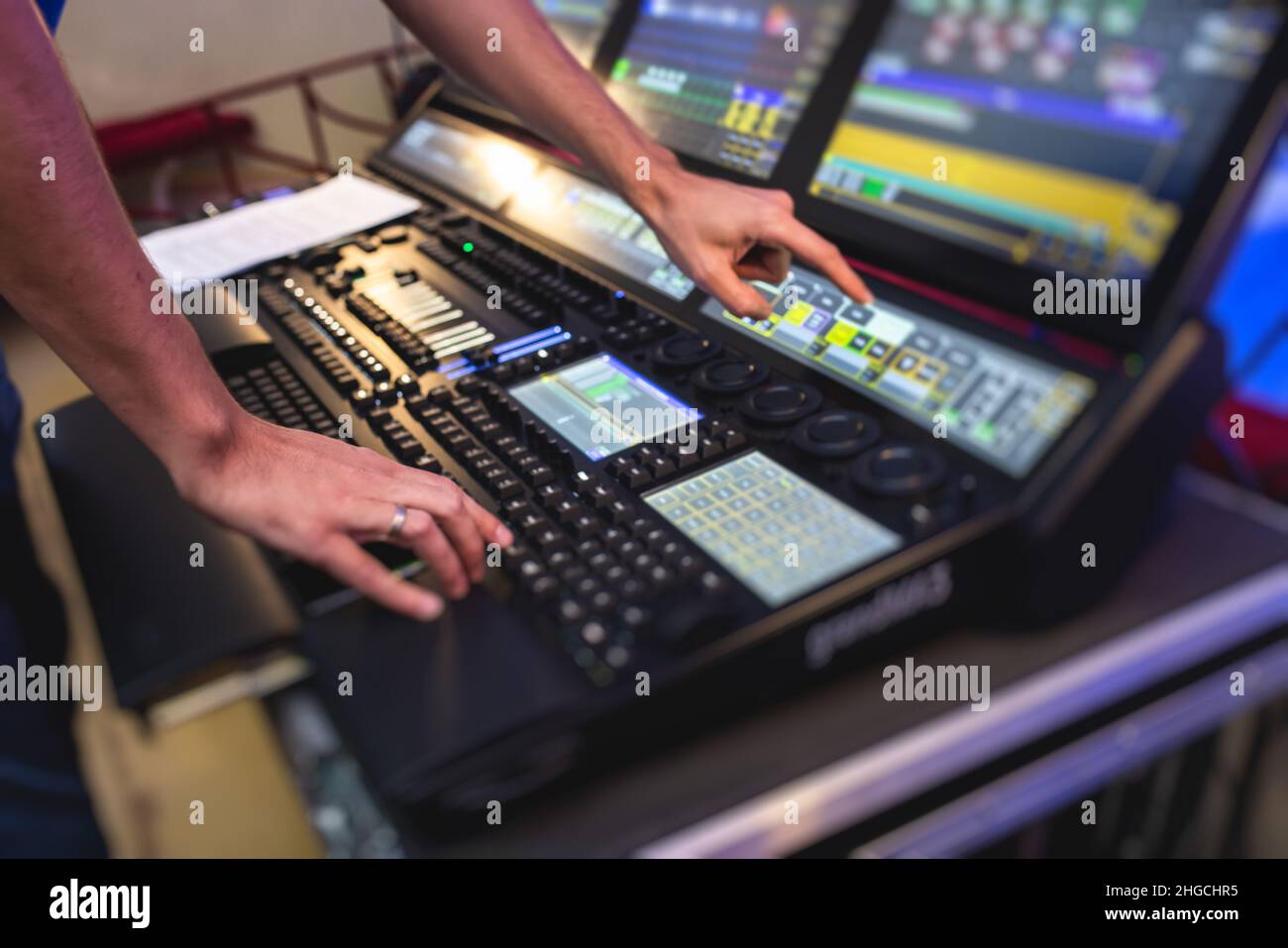 View of lighting technician operator working on mixing console