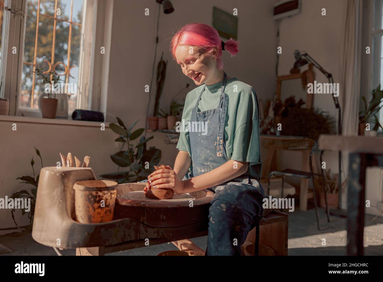 Young potter working with clay in workroom Stock Photo