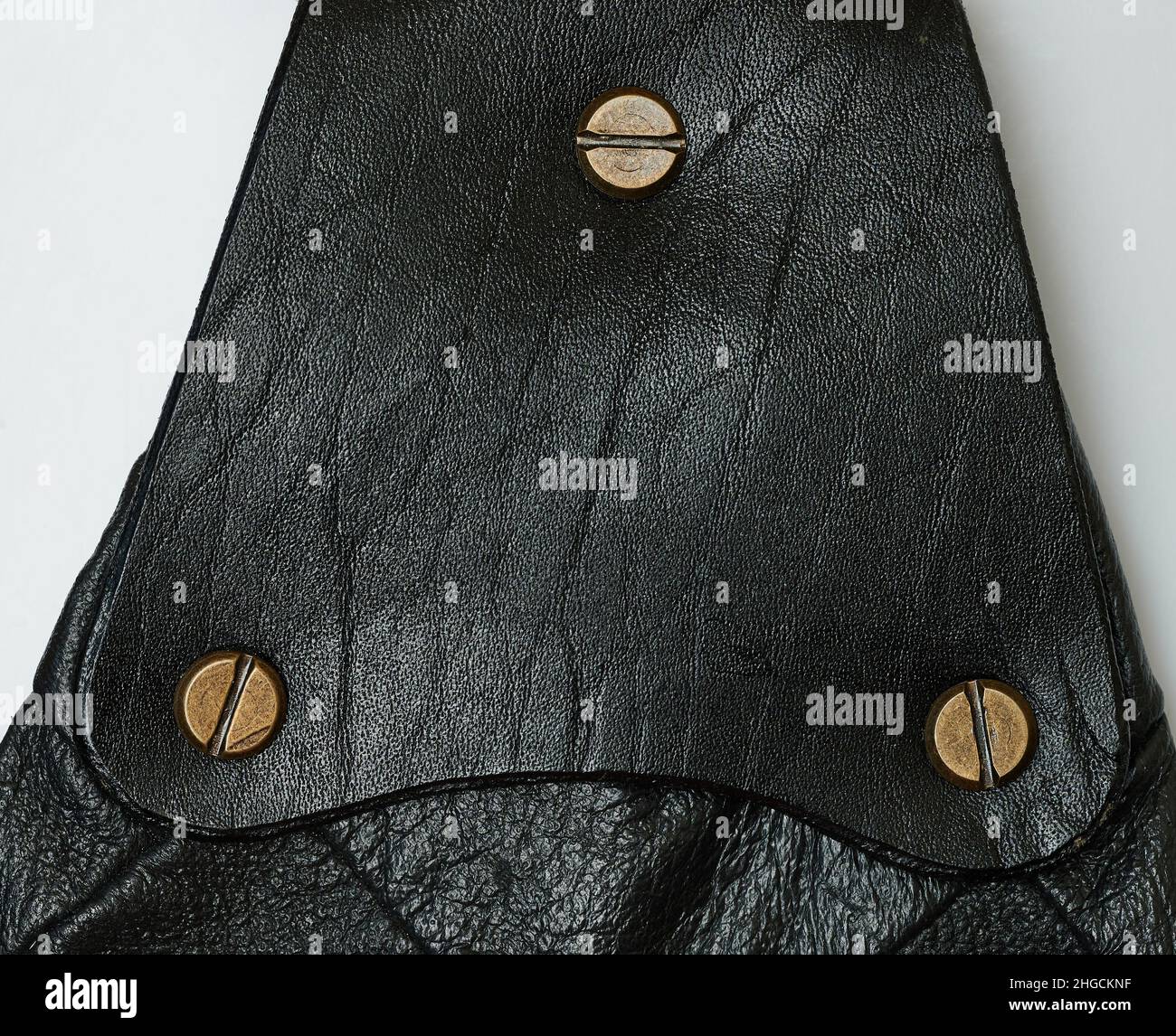 Black leather patch with metal screw isolated on studio background Stock Photo