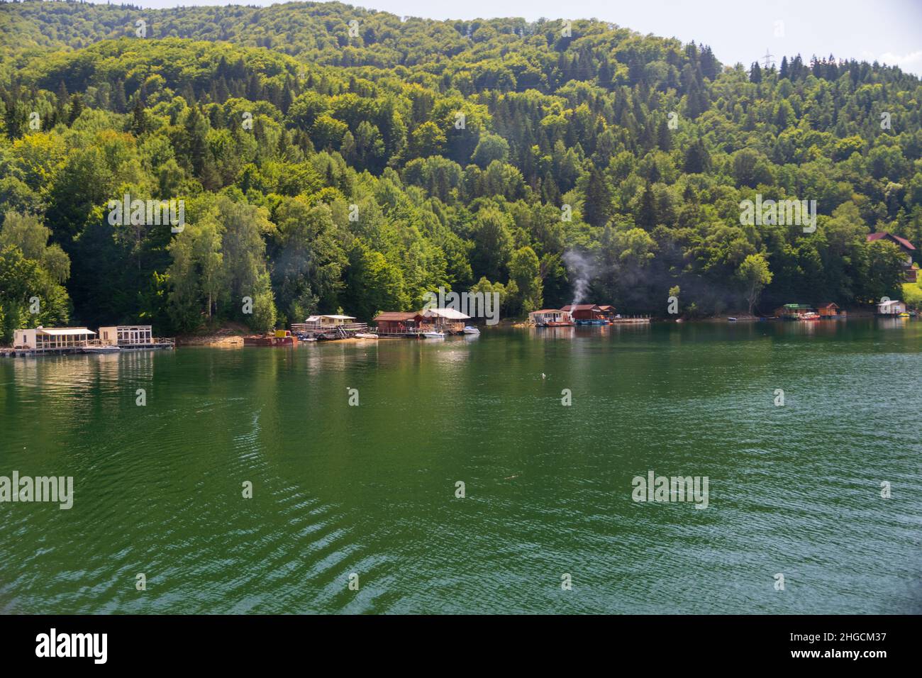 Buildings on the shore of Lake Izvorul Muntelui on a sunny day, Lake Bicaz, Piatra Neamt, Romania Stock Photo