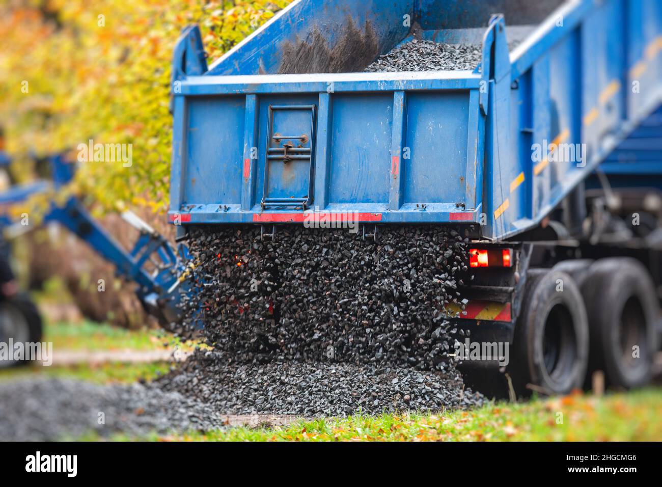 Dump truck, tractor and bulldozer unloading gravel, road metal, rubble