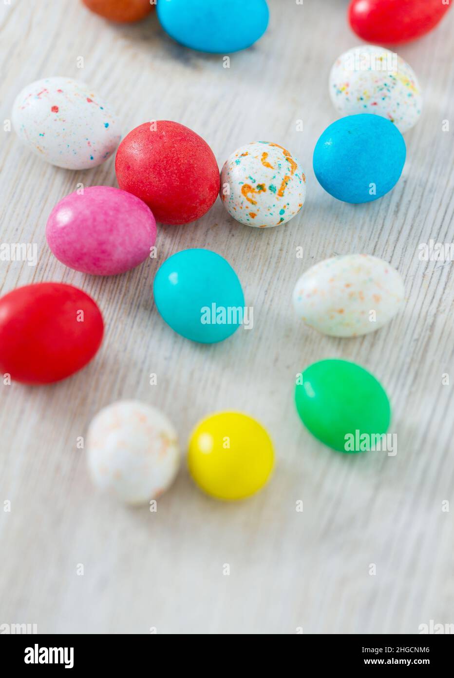 Easter candy eggs on white wooden surface Stock Photo