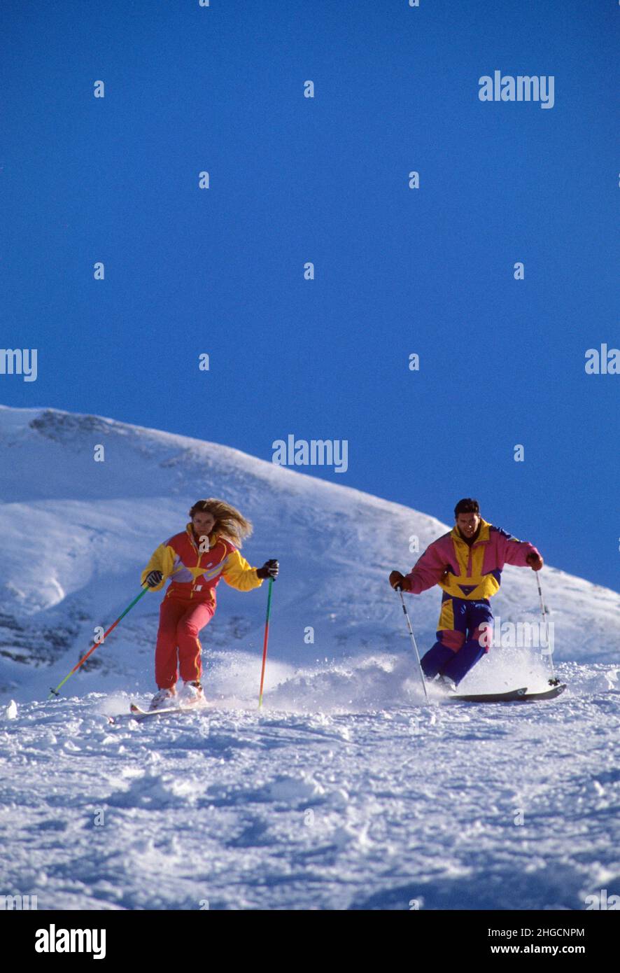 couple skiing the alps france colored clothes blue sky on background Stock Photo