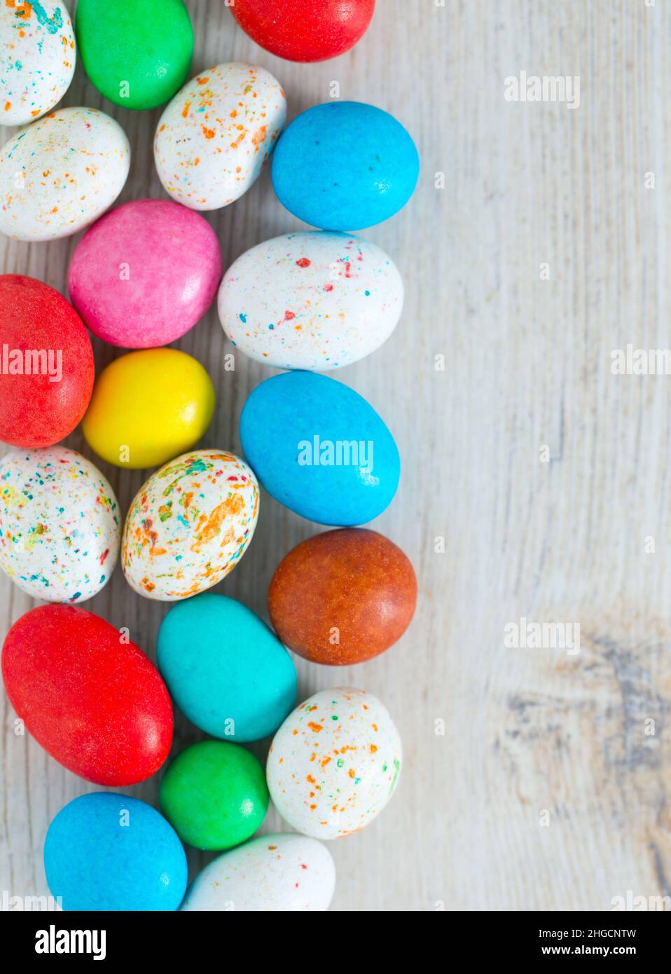 Easter candy eggs on white wooden surface Stock Photo
