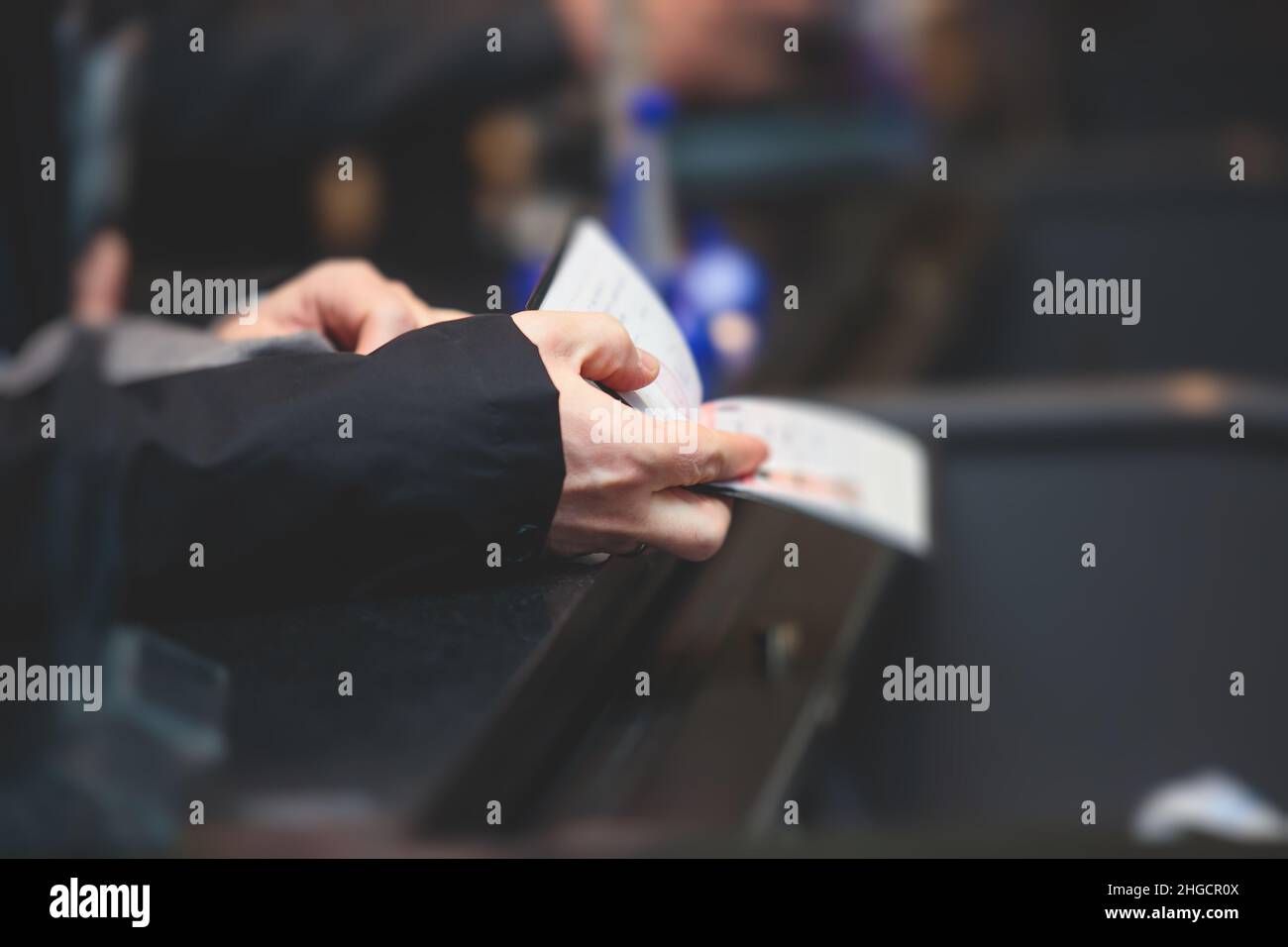 Process of checking in on  conference congress forum event, registration desk table, visitors and attendees receiving a name badge and entrance wristb Stock Photo