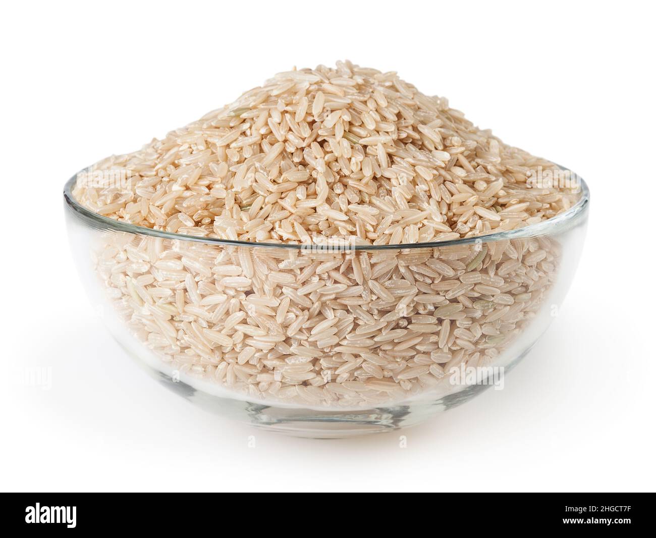 Uncooked brown rice in glass bowl isolated on white background Stock Photo