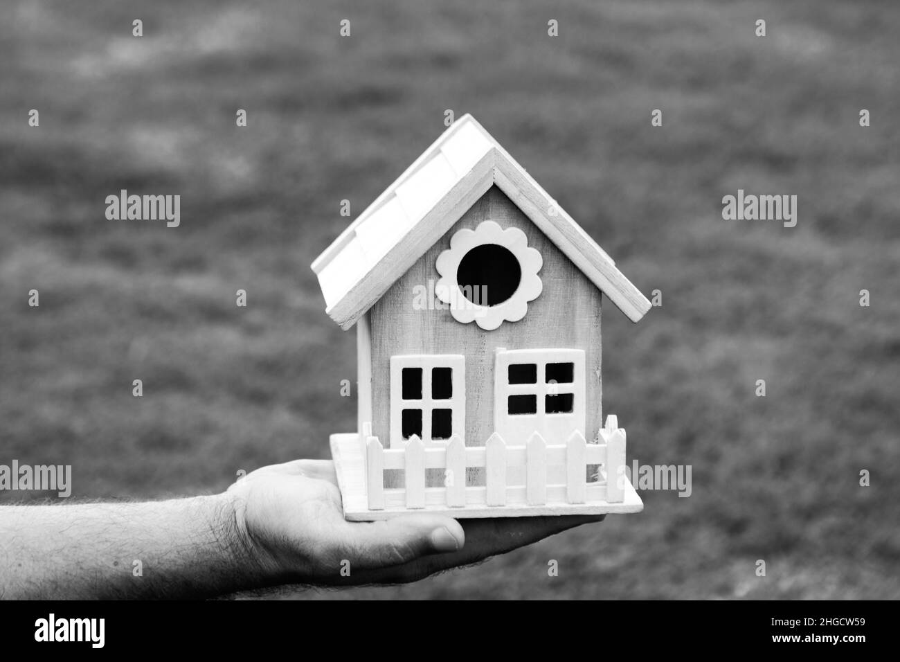 Male hands holding small miniature toy house. Mortgage property insurance dream moving home and real estate concept. Home insurance. New house. Stock Photo