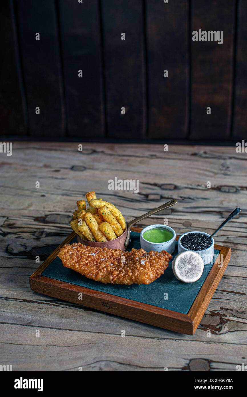 Luxury fish and chips :Deep Fried Turbot with The Hand & Flowers Chips, Caviar Tartare Sauce and Minted Pea Purée at The Hand and Flowers, award winni Stock Photo