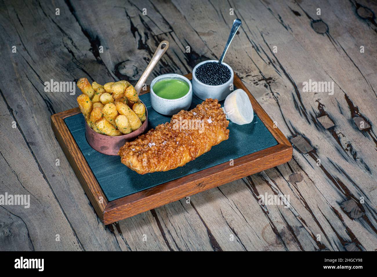 Luxury fish and chips :Deep Fried Turbot with The Hand & Flowers Chips, Caviar Tartare Sauce and Minted Pea Purée at The Hand and Flowers, Stock Photo