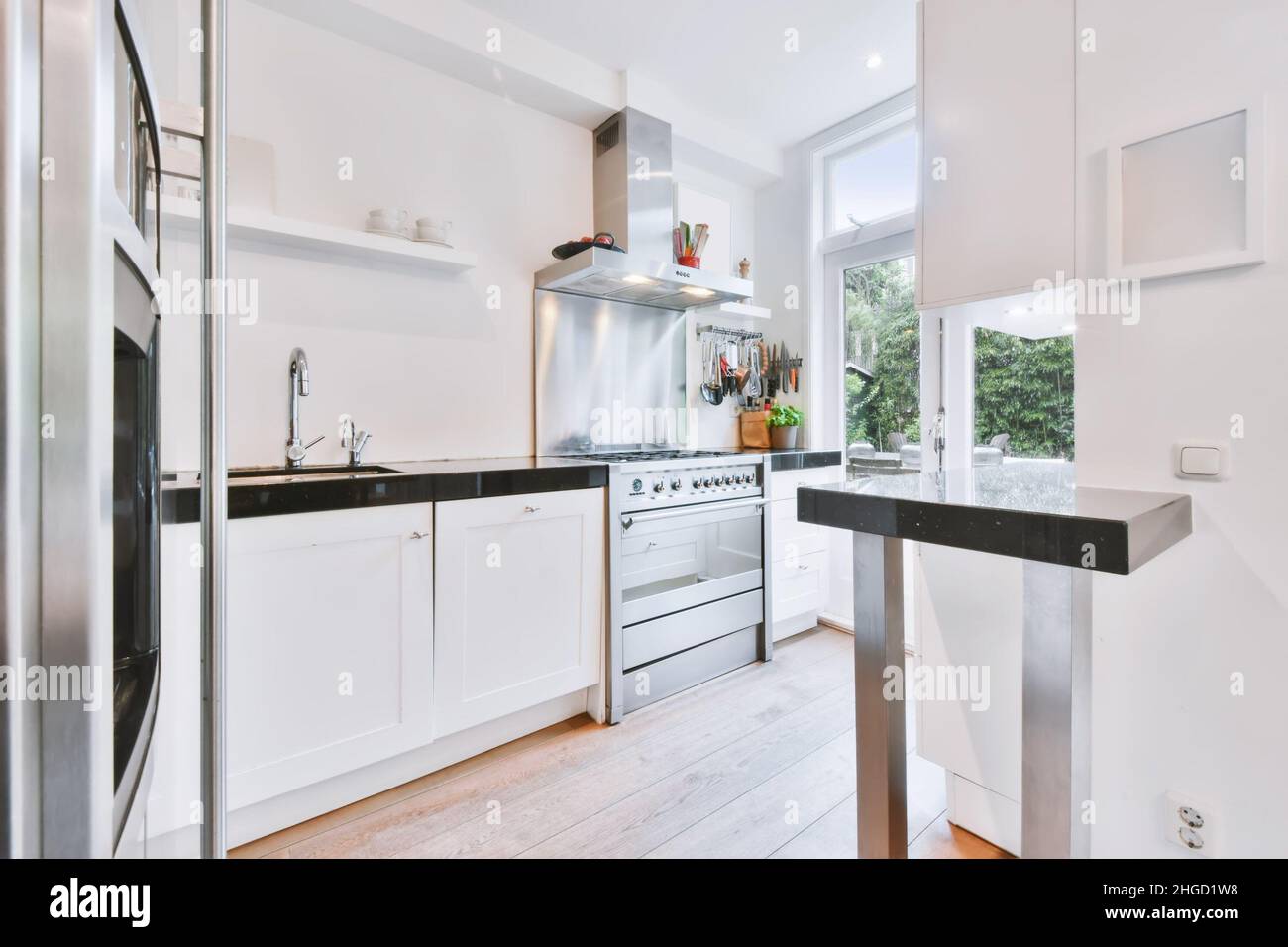 Charming kitchen with black countertop and modern gas stove Stock Photo ...