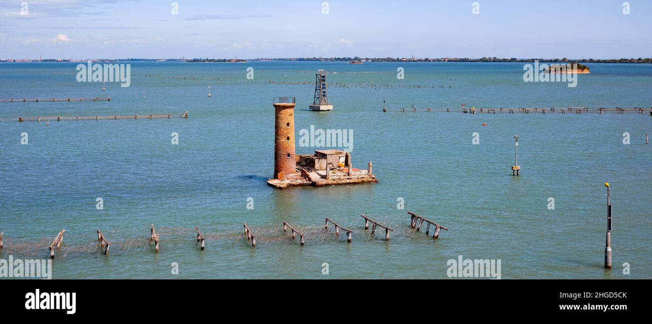 small island with an old tower in the sea next to venice Stock Photo