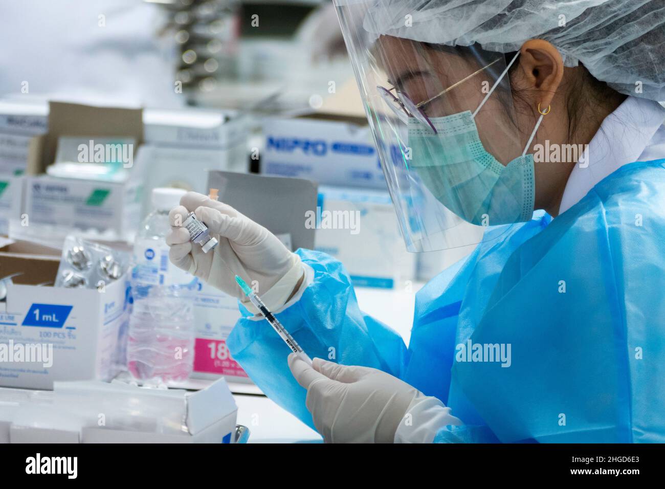 Bangkok, Thailand - January 25, 2022 : doctor taking coronavirus vaccine into syringe for injecting omicron covid booster vaccination. Stock Photo
