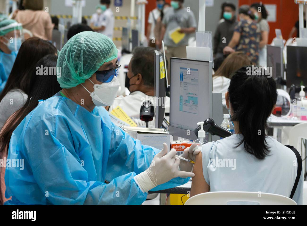 Bangkok, Thailand - January 24, 2022 : asian doctor giving omicron covid antiviral vaccine booster dose to woman. Stock Photo
