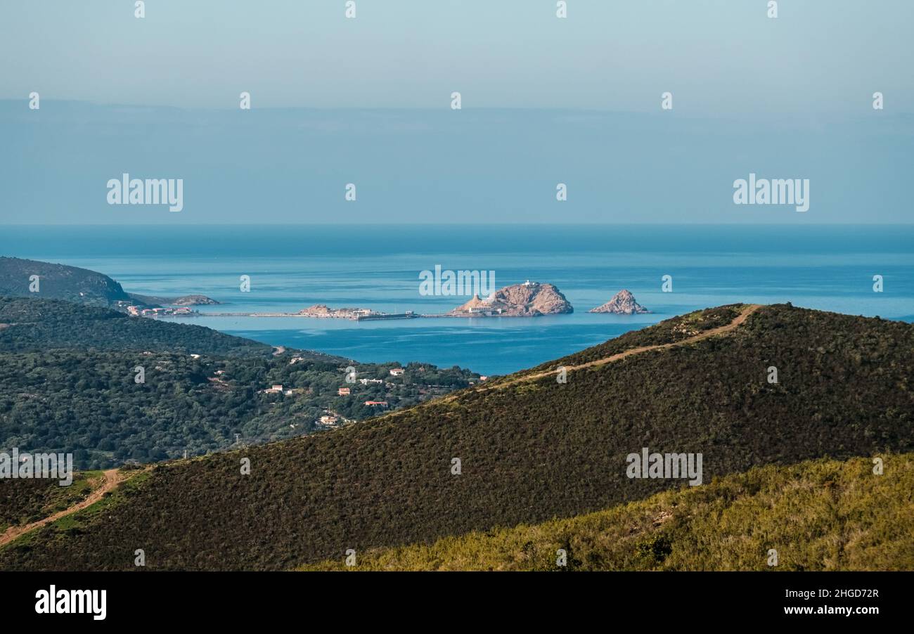 The red rock, La Pietra, and harbour of Ile Rousse in the Balagne ...