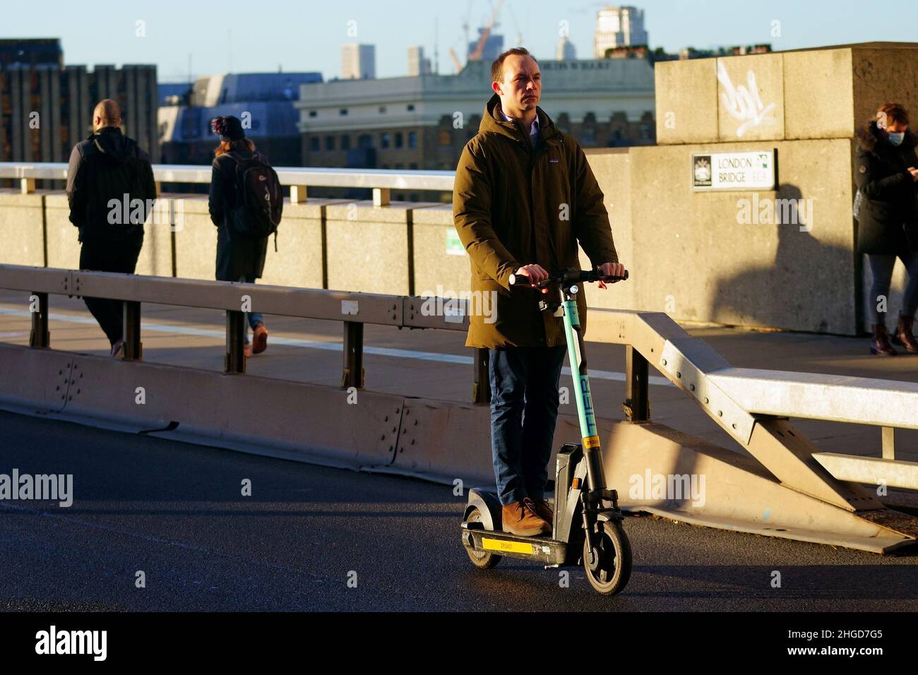 A commuter on an electric scooter crosses London Bridge make their way into offices during the morning rush hour after advice to work from home was dropped on Wednesday by Prime Minister Boris Johnson. Picture date: Thursday January 20, 2022. Stock Photo