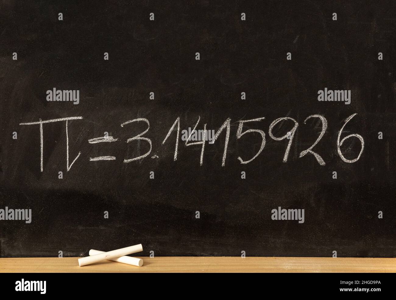 Pi number, mathematical constant chalk drawing on a school black board, Greek letter symbol and decimal digits chalk handwriting Stock Photo